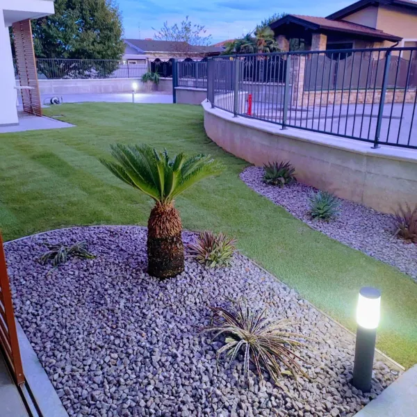 Giardino brescia con piccole palme e piante tropicali e prato verde: Il Lauro Brescia